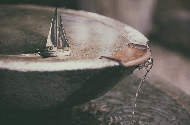 silver colored, outdoors, metal, selective focus, close-up, 1080P, still life, drink, boat, old, ship, container, high angle view, water, day, land, miniature