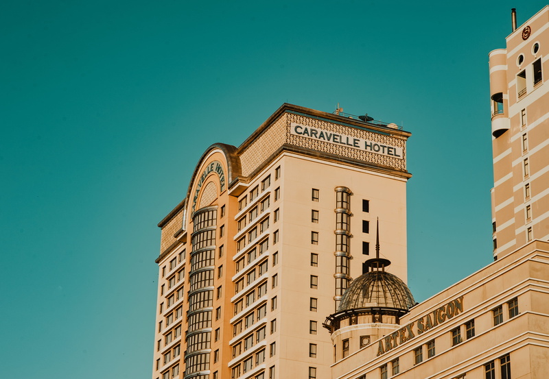 building, sunlight, window, travel destinations, outdoors, architecture, hotels, downtown, low angle shot, caravelle hotel, tower, skyscraper, day, built structure