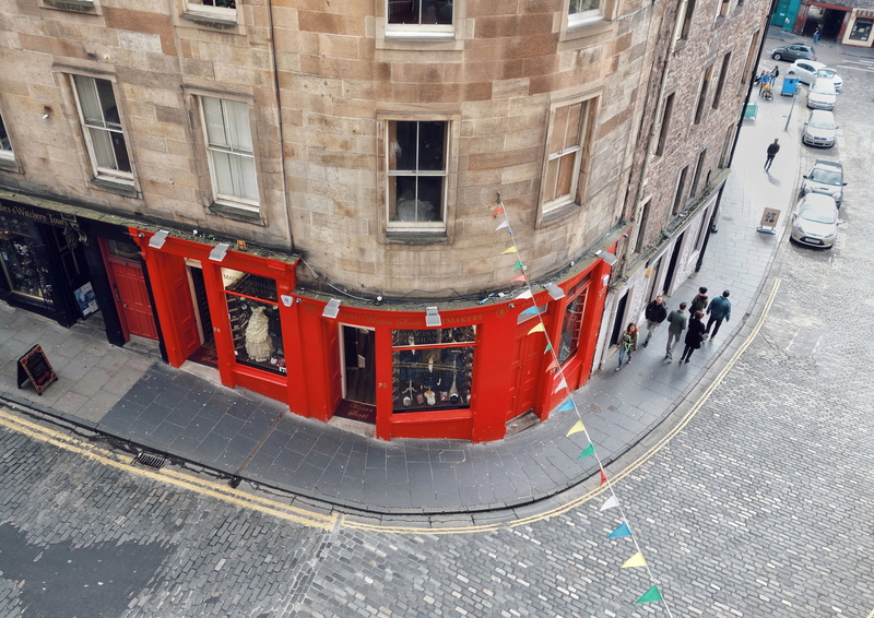 window, building exterior, string pennants, outdoors, day, footpath, real people, above, 4K, architecture, corner, transportation, high angle view, red