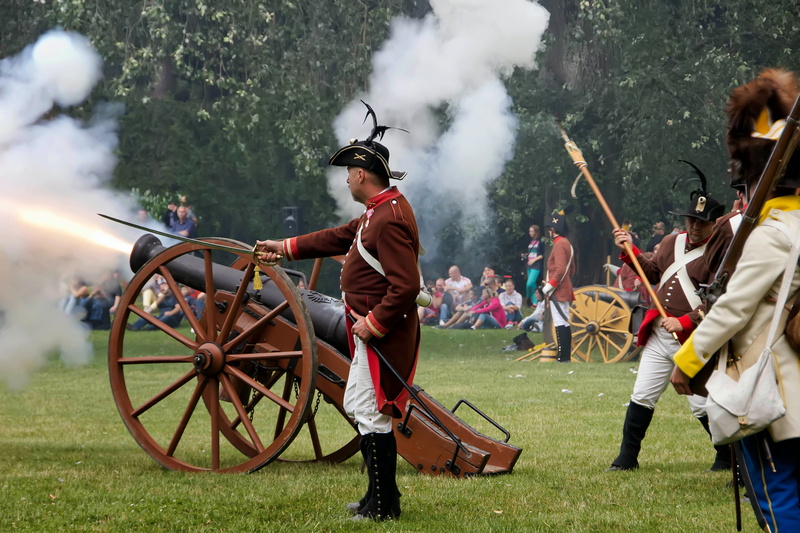 wheel, men, leisure activity, grass, field, lifestyles, cannon, plant, holding, napoleon, 5K, smoke - physical structure, people, shooting, group of people