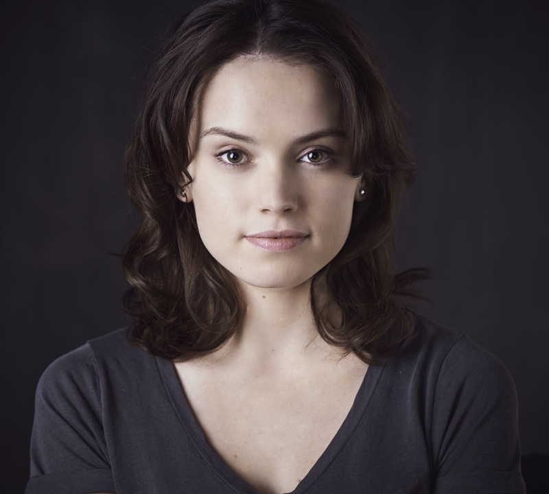 looking at camera, v-neck, brunette, Daisy Ridley, studio shot, indoors, contemplation, human face, shirt, black background, hairstyle, headshot, curly hair