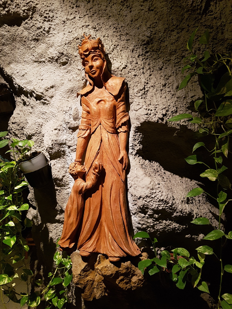 religion, human representation, holy, outdoors, wall - building feature, representation, catholic, statue, sacral, plant part, nature, chapel, art and craft