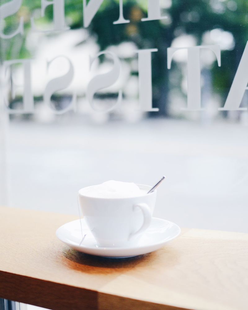 coffee cup, spoon, surface, tea cup, non-alcoholic beverage, eating utensil, blur, glass, day, tea, table, drink, freshness, cafe, crockery, white, food and drink