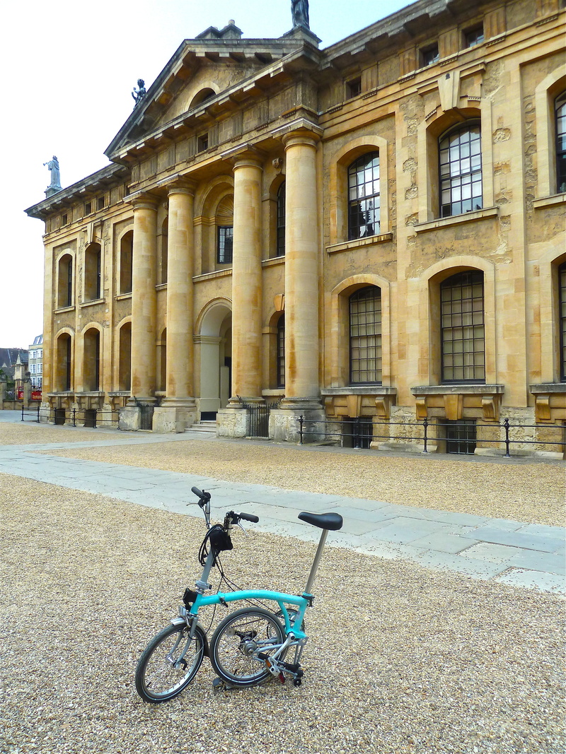 building, mode of transportation, travel destinations, architectural column, architecture, land vehicle, people, brompton, street, bicycle, wheels, city