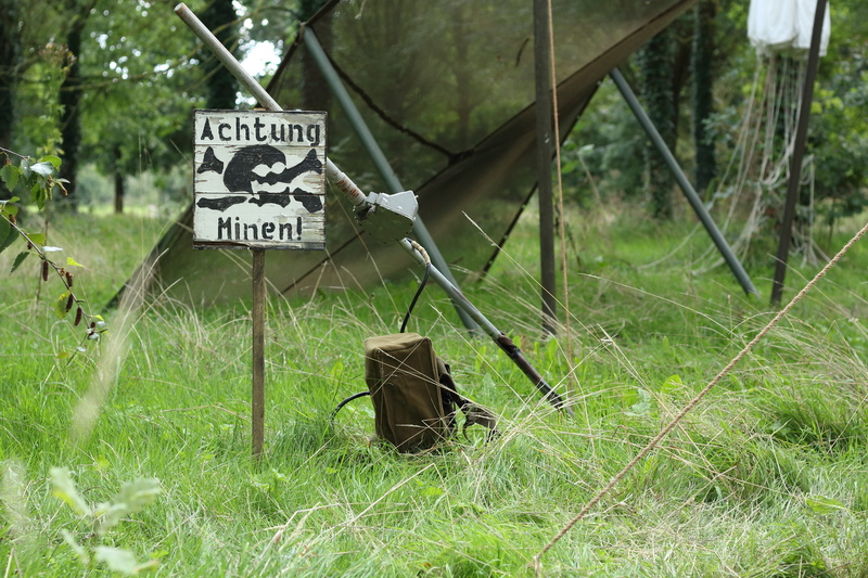 text, sign, grass, mines, nature, outdoors, war, dangerous, tranquility, green color, guidance, no people, mine, 5K, conflict, military, tree, day, danger