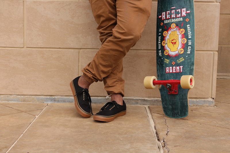 motion, real people, skateboard, casual clothing, green, floor, sneakers, leaning, holding, indoors, sport, longboard, tiled floor, man, footwear, standing