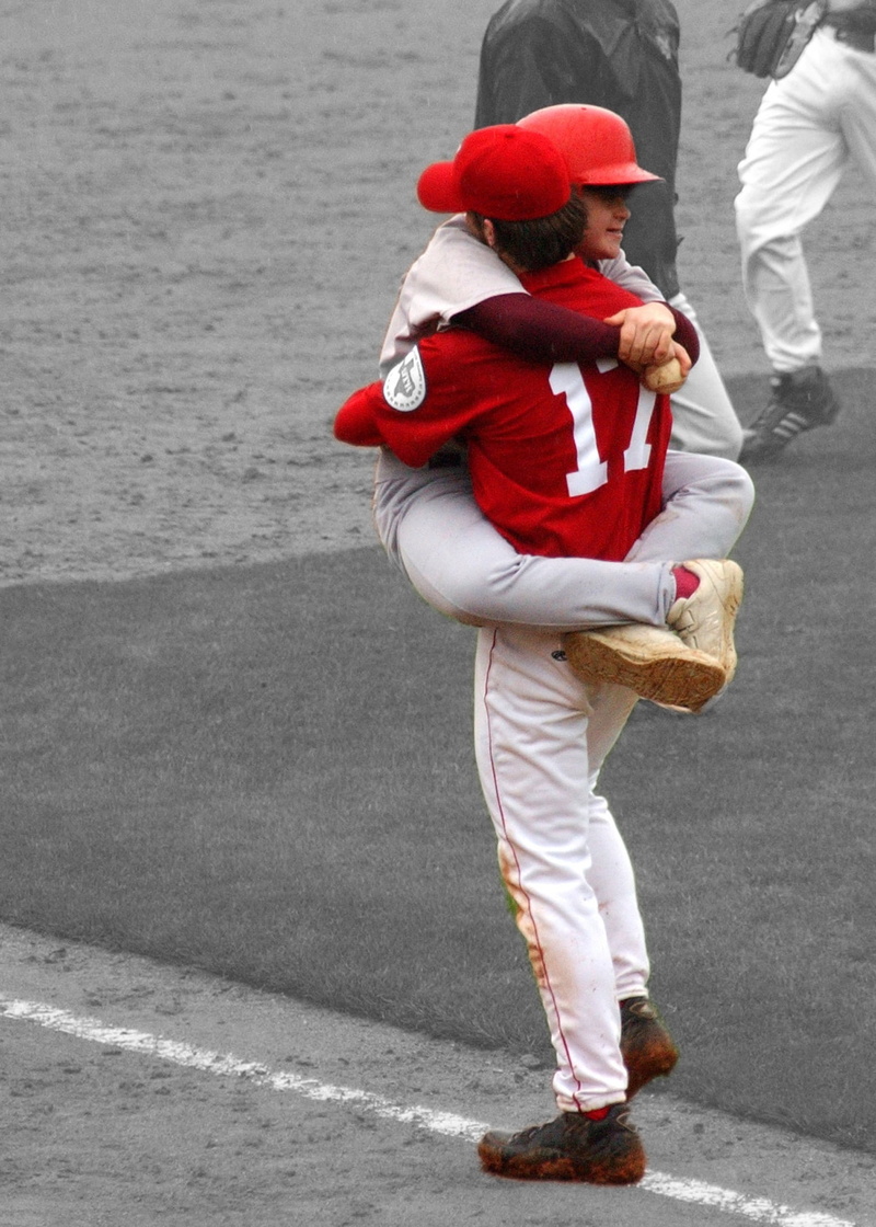 warm clothing, hug, men, baseball player, holding, leisure activity, street, outdoors, clothing, togetherness, winter, city, red, emotion, adult, bat boy