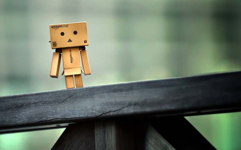 robot, cardboard robot, outdoors, representation, still life, built structure, table, technology, railing, day, creativity, no People, figurine, focus on foreground