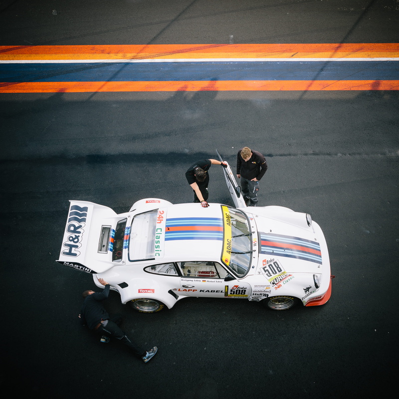 mode of transportation, white, day, car, high angle view, symbol, land vehicle, road marking, crew, rear view, classic, transportation, pit, full length