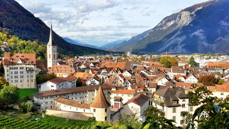 town, community, chur, orange roof, townscape, building exterior, clock tower, roof, nature, sky, built structure, architecture, high angle view, historic