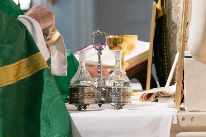 latin mass, food and drink, drink, casual clothing, trophy, holy water, furniture, service, men, container, indoors, business, bishop, focus on foreground