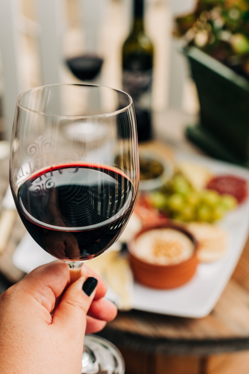 wine, one person, near, glass, table, cheese platter, red wine, beverage, goblet, luxury, wineglass, coffee cup, bread, body part, dating, home decor, bottle