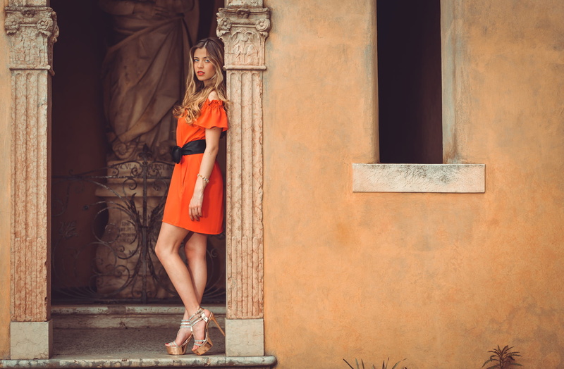 orange dress, women outdoors, real people, Marco Squassina, one person, long hair, built structure, architectural column, wall - building feature, hairstyle