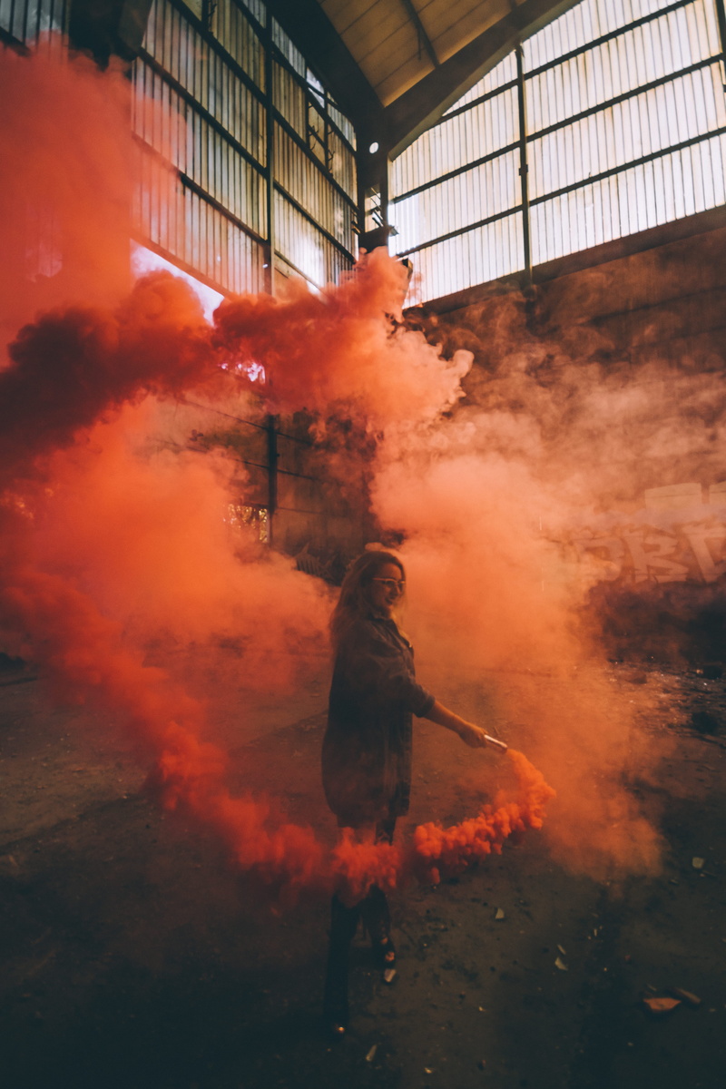 factory, fire - natural phenomenon, adult, woman, women, human, person, 5K, smoke, holding, orange, architecture, bomb, day, hairstyle, photography, full length