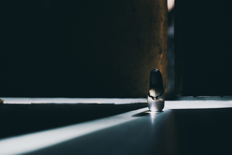 high angle view, dark, figurine, reflection, light - natural phenomenon, spirited, spotlight, single object, still life, shadow, black color, close-up