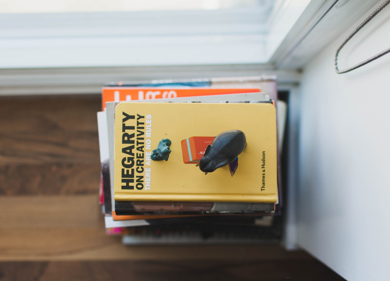 no People, vehicle interior, book, still life, text, window sill, communication, animal, public transportation, white, selective focus, stack, yellow, indoors
