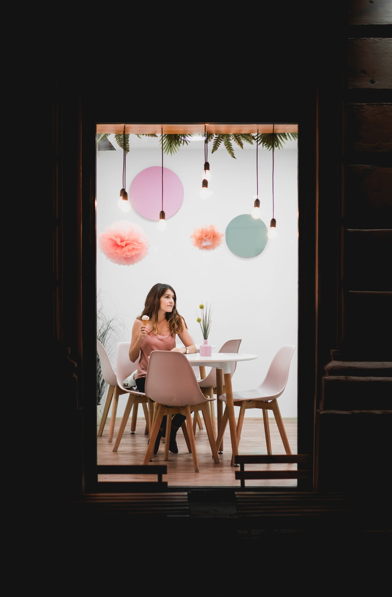 female, one person, young women, adult, furniture, light, treat, frame, indoors, table, casual clothing, eat, window, lifestyles, holding, interior design