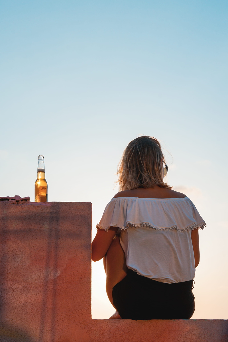 real people, women, wall, sunset, summer vibe, food and drink, sky, sit, female, bottle, nature, view, casual clothing, white, adult, sitting, alcohol