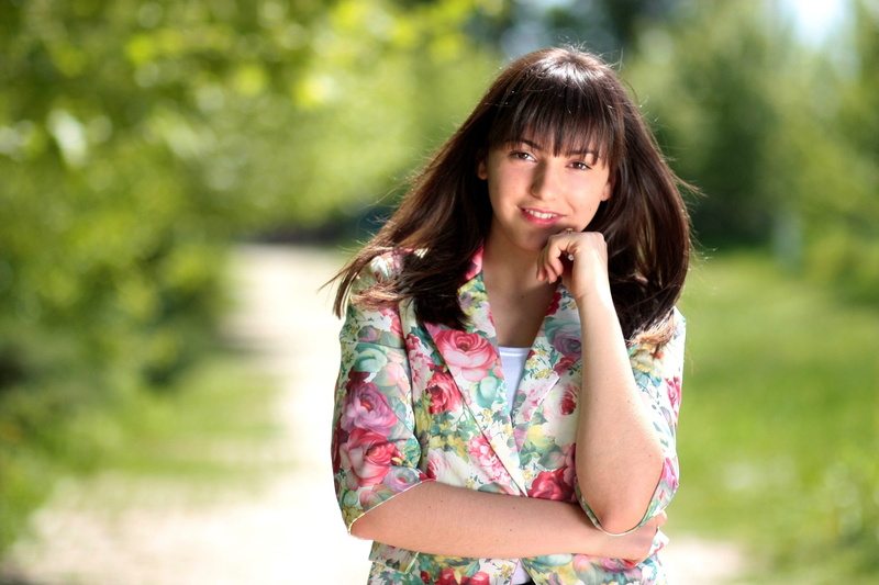 park, smiling, floral pattern, brown hair, focus on foreground, contemplation, long hair, one woman only, floral, standing, adults only, adult, beauty