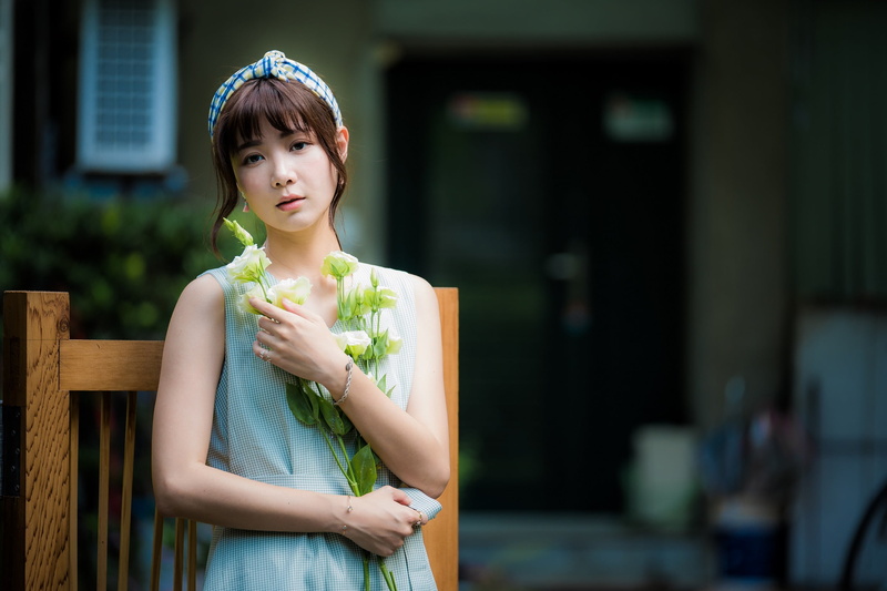 front view, bangs, outdoors, portrait, adult, brunette, depth of field, looking, Asian, 1080P, head band, leisure activity, waist up, standing, flowers
