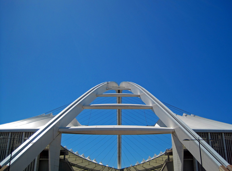 stadium, side view, no people, nature, sunny, blue, clear sky, copy space, grid, building exterior, bridge, outdoors, sky, glass, day, directly below, roof