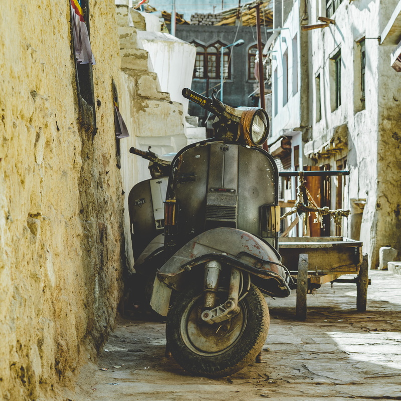 leh, motor, traditional design, beside, travel, transport, wheel, transportation, motorcycle, mode of transportation, stationary, wall, day, outdoors, urban