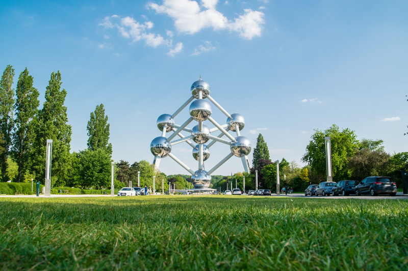 built structure, day, atomium, bruxelles, building exterior, outdoors, land, park, sky, growth, plant, tree, car, cloud - sky, field, mode of transportation