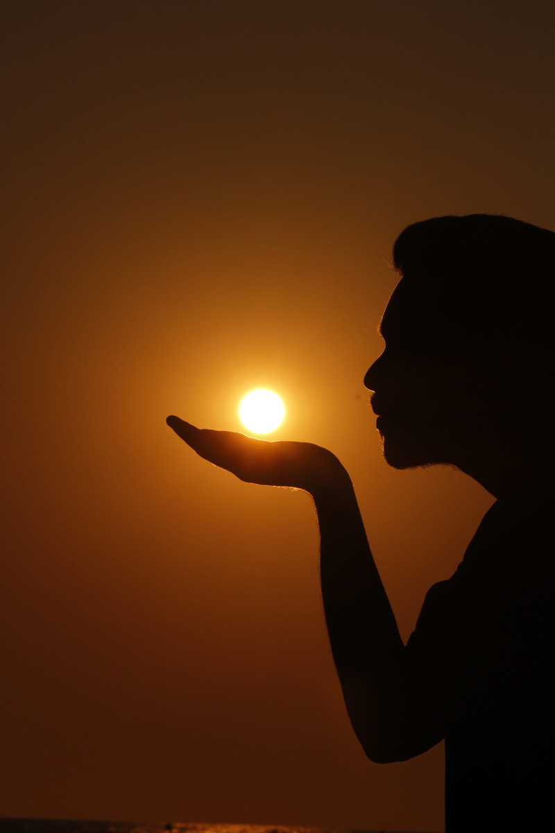 outdoor, optical illusion, one person, autumn, beauty in nature, shade, sunset, delight, finger, lifestyles, nature, side view, holding, real people, sea