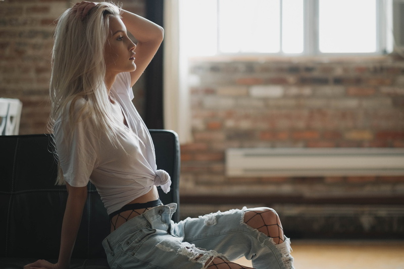 real people, focus on foreground, Kang Lee, indoors, torn jeans, brick, young adult, one person, beautiful woman, lifestyles, 1080P, young women, sitting