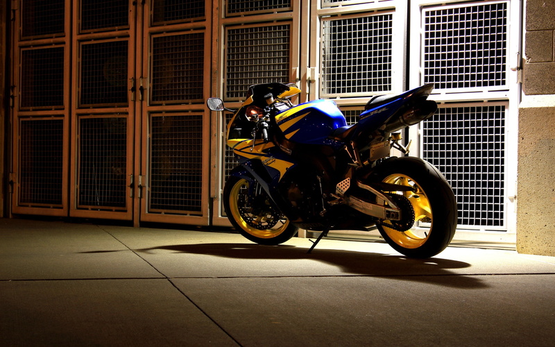 full length, sports, building exterior, editorial, night, street, tiled floor, yellow, motorcycle, blue, helmet, land Vehicle, built structure, side view