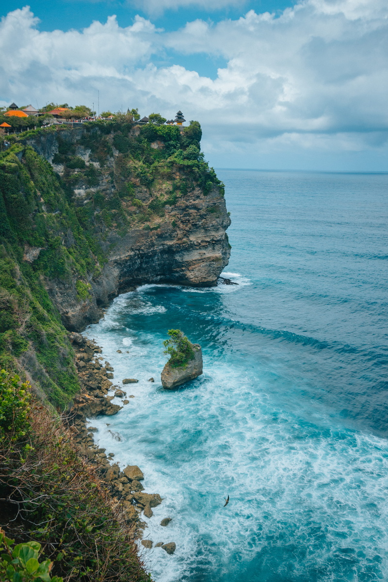 shoreline, sky, cliff, mountain, rock formation, water, beauty in nature, beside, scenery, idyllic, leisure activities, day, landscape, ocean, uluwatu