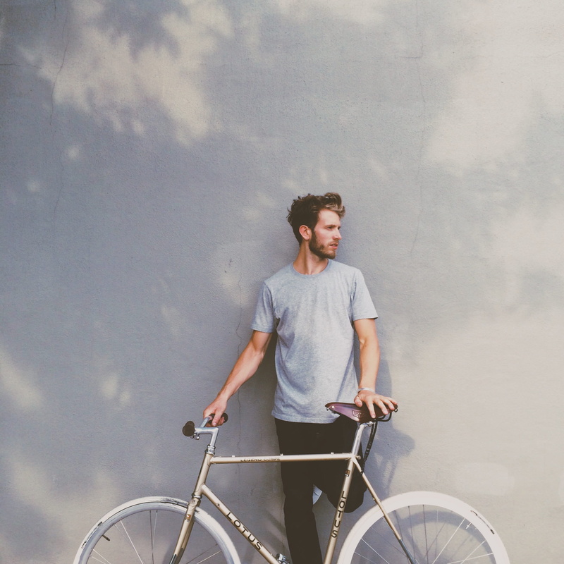 bike, real people, lifestyle, leisure activity, person, day, male, wall, casual, outdoors, young, looking away, three quarter length, adult, cycle, one person