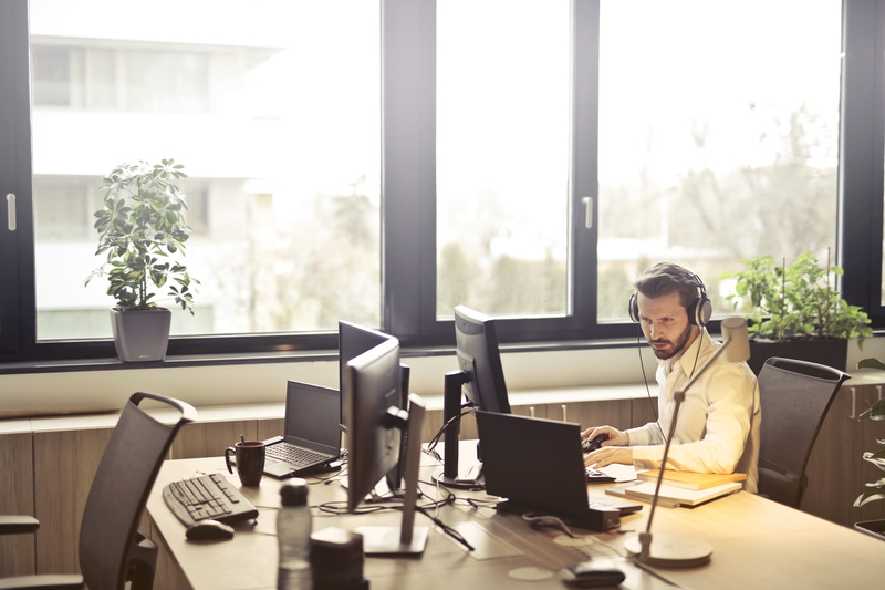 laptop, wireless technology, headset, furniture, entrepreneur, employee, computer, room, seat, businessman, computer monitor, sit, person, sitting, chair