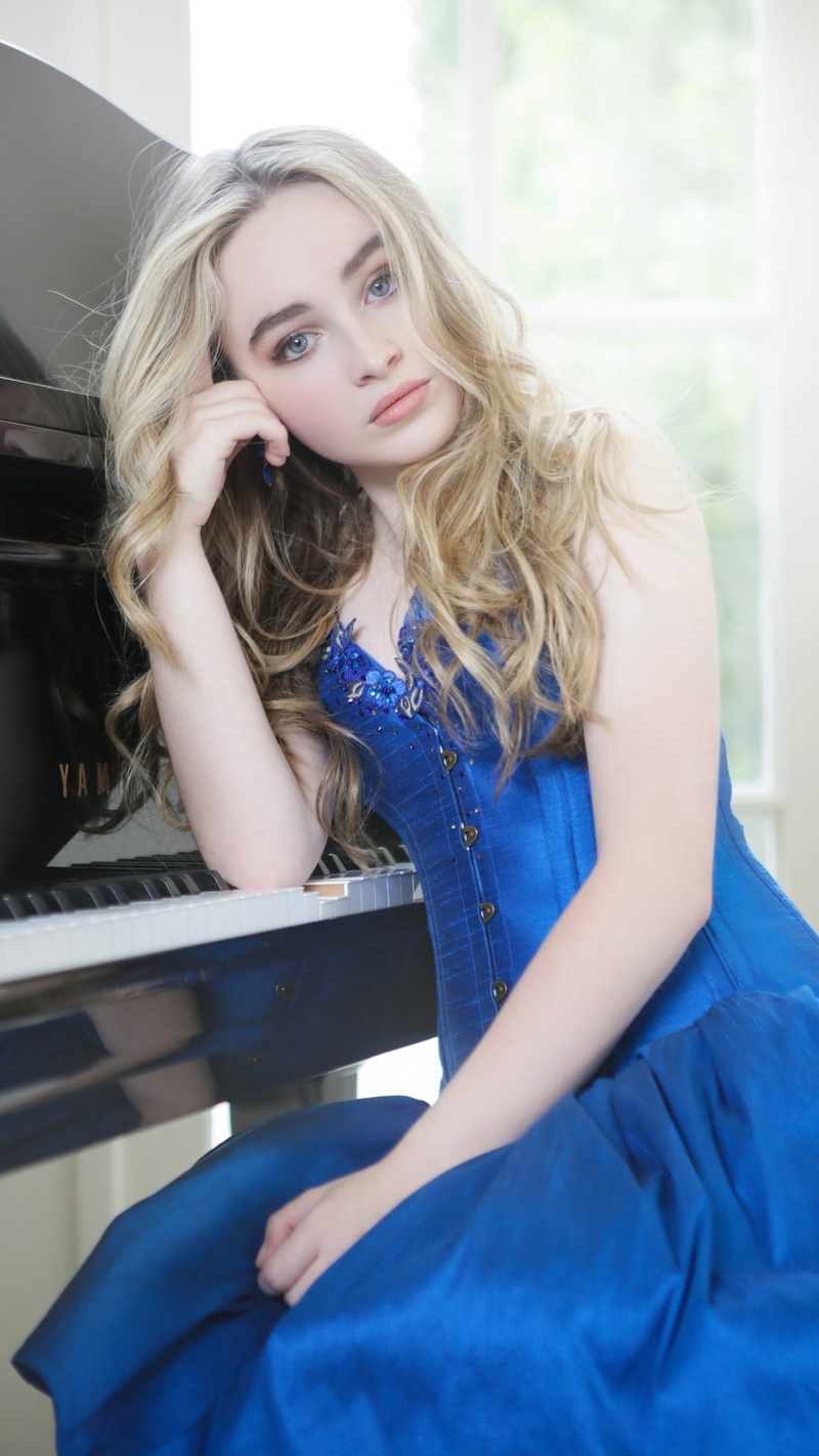 young adult, blond hair, singer, looking at camera, s, contemplation, three quarter length, day, Music, sleeveless, beautiful woman, home interior, women