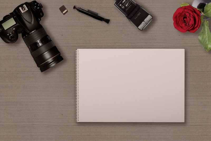 publication, book, indoors, table, digital camera, directly above, hotshoe-mounted flash, copy space, photograph, writing instrument, photographic equipment