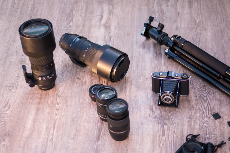 camera - photographic equipment, old camera, camera tripod, group of objects, telephoto lens, wood, facilities, directly above, memory cards, technology