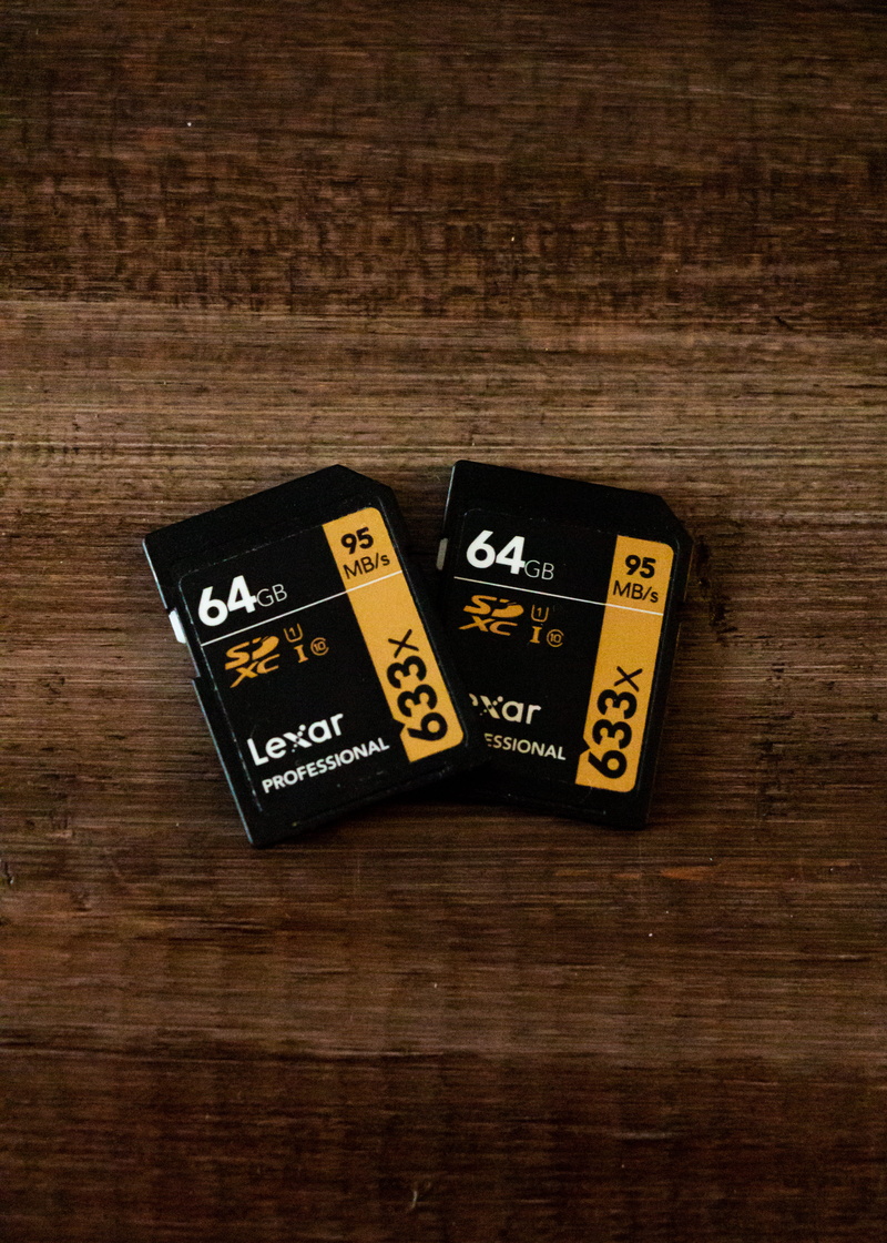 group of objects, black, cards, weapon, text, indoors, lexar, hardware, table, still life, number, two, ammunition, close-up, game of chance, electronics