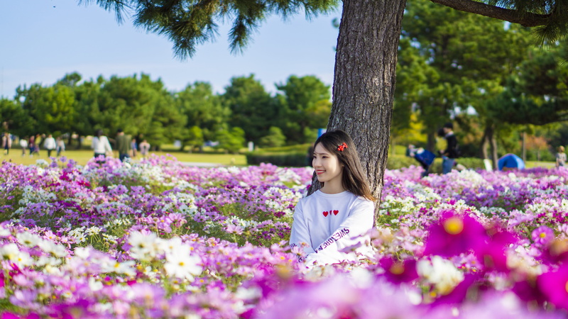 middle, purple, flower, smile, growth, woman, outdoors, bloom, casual clothing, land, hair, female, beautiful woman, nature, photoshoot, happiness, real people