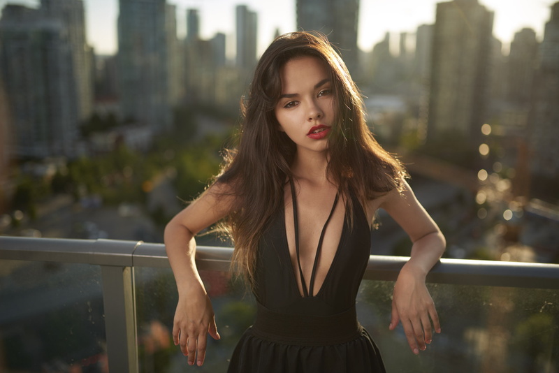 front view, women, 1080P, one person, beauty, lifestyles, city, standing, architecture, balcony, outdoors, hair, depth of field, long hair, focus on foreground