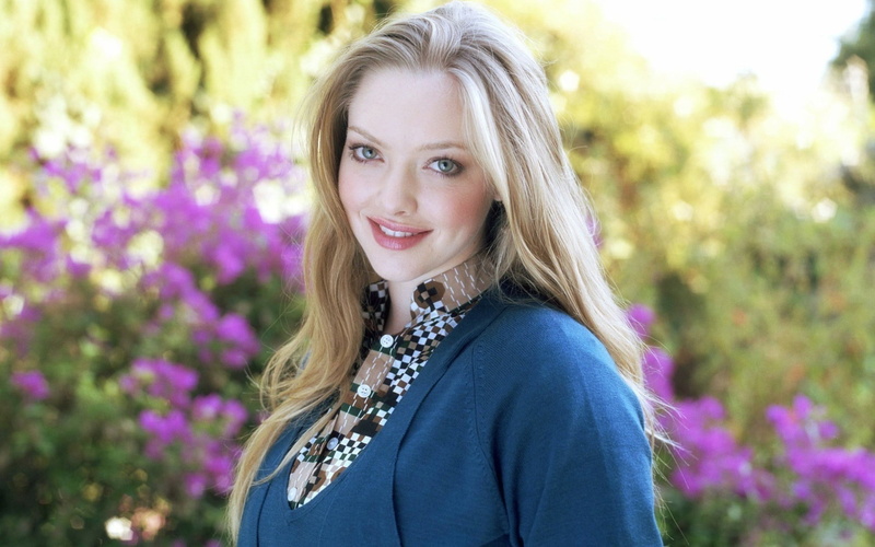 headshot, focus on foreground, blond hair, Amanda Seyfried, smiling, s, portrait, hair, beautiful woman, purple, adult, flower, outdoors, celebrity, top