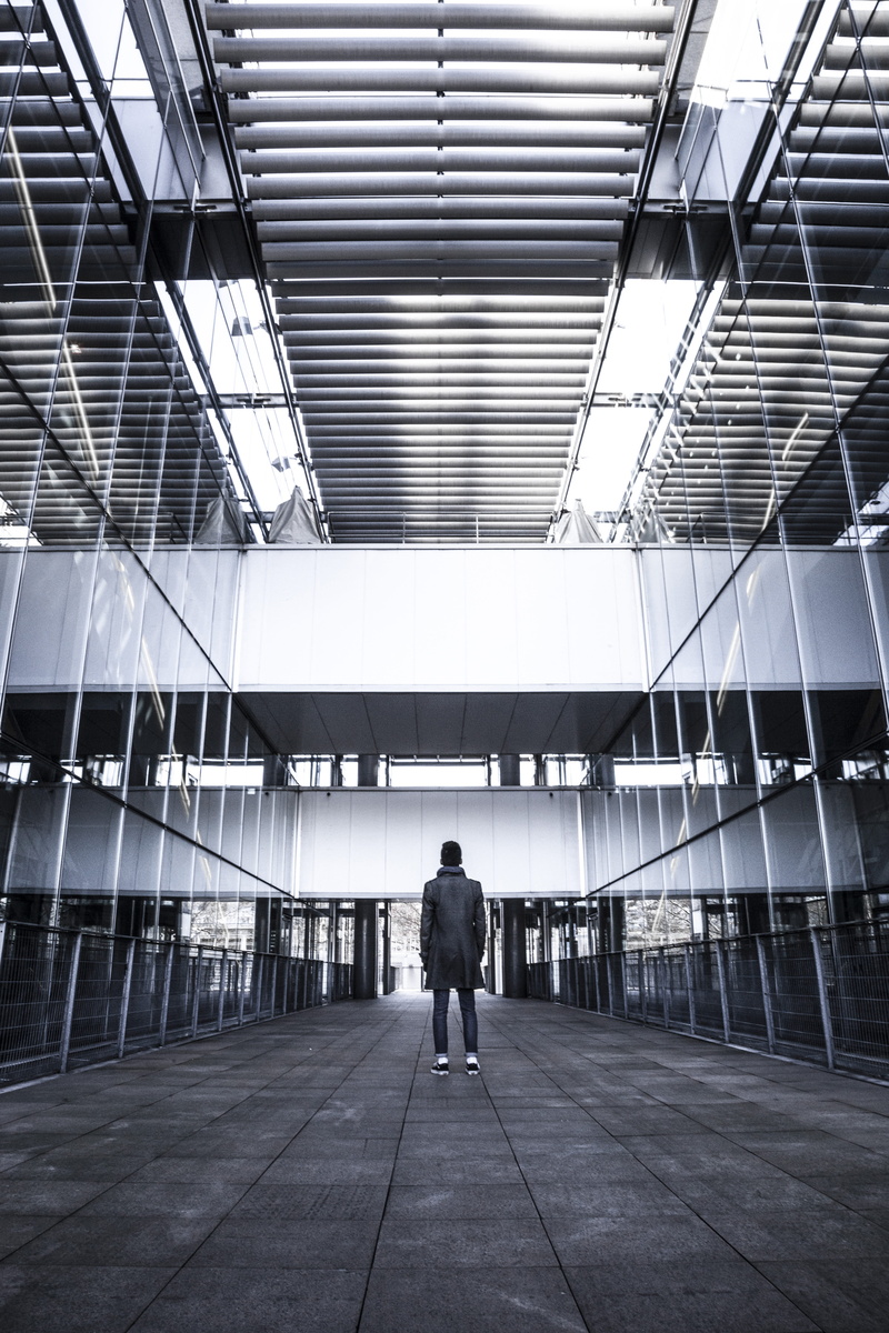 back, built structure, direction, black, walking, person, day, full length, real people, wall, the way forward, reflection, building, architecture, leisure activity