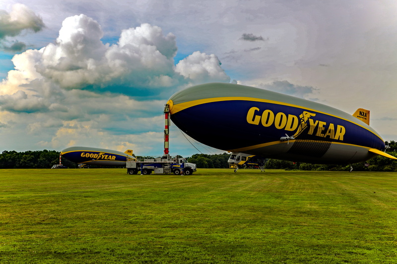 aerospace industry, sky, nature, airport, wingfoot two, grass, mode of transportation, cloud - sky, outdoors, no people, flying, public transportation
