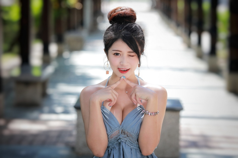 looking at viewer, outdoors, wink, looking at camera, hair, Asian, young adult, portrait, focus on foreground, brunette, beauty, depth of field, real people