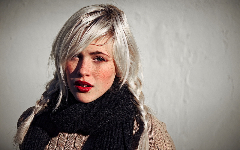 clothing, hair, long hair, blond hair, scarf, headshot, human hair, wall - building feature, looking at camera, warm clothing, sweater, model, adult, white hair