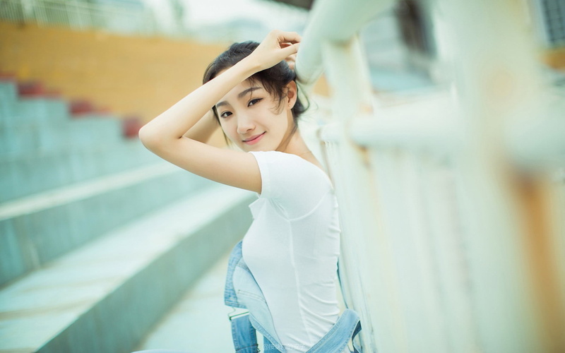 one person, real people, outdoors, day, casual clothing, young women, arms up, focus on foreground, hairstyle, portrait, three quarter length, young adult