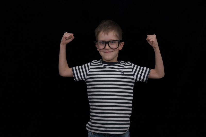 black background, boys, boy, eyeglasses, indoors, child, kid, raising, offspring, human arm, studio shot, glasses, males, standing, one person, front view