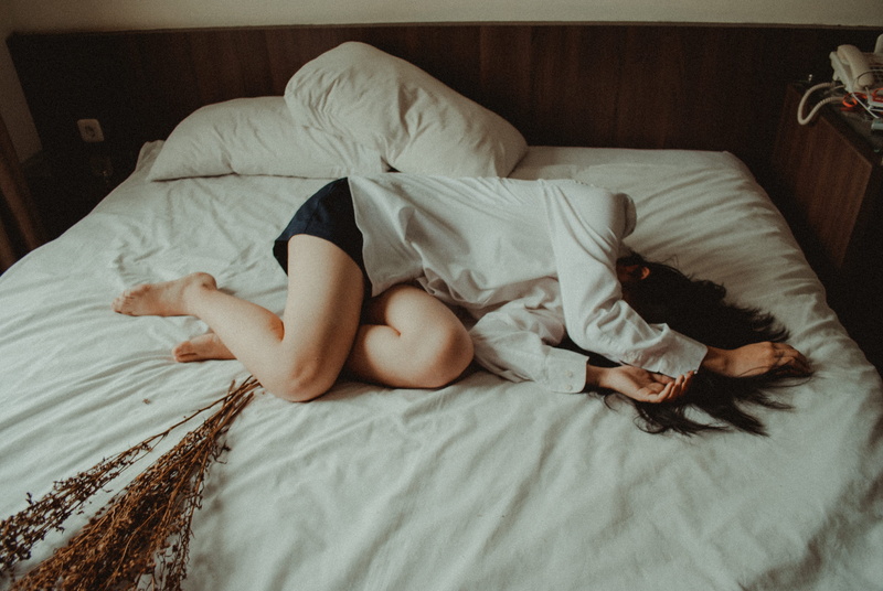 relaxation, lying on side, lifestyles, young adult, sad, bedroom, one person, sleeping, sleep, sleeved, caucasian, black, shorts, domestic room, lying