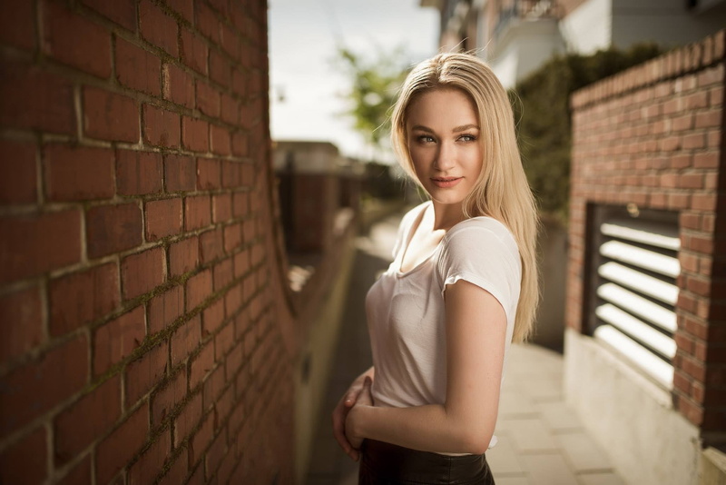 standing, women, looking away, adult, contemplation, brick wall, architecture, blond hair, casual clothing, top - garment, beautiful woman, looking at camera