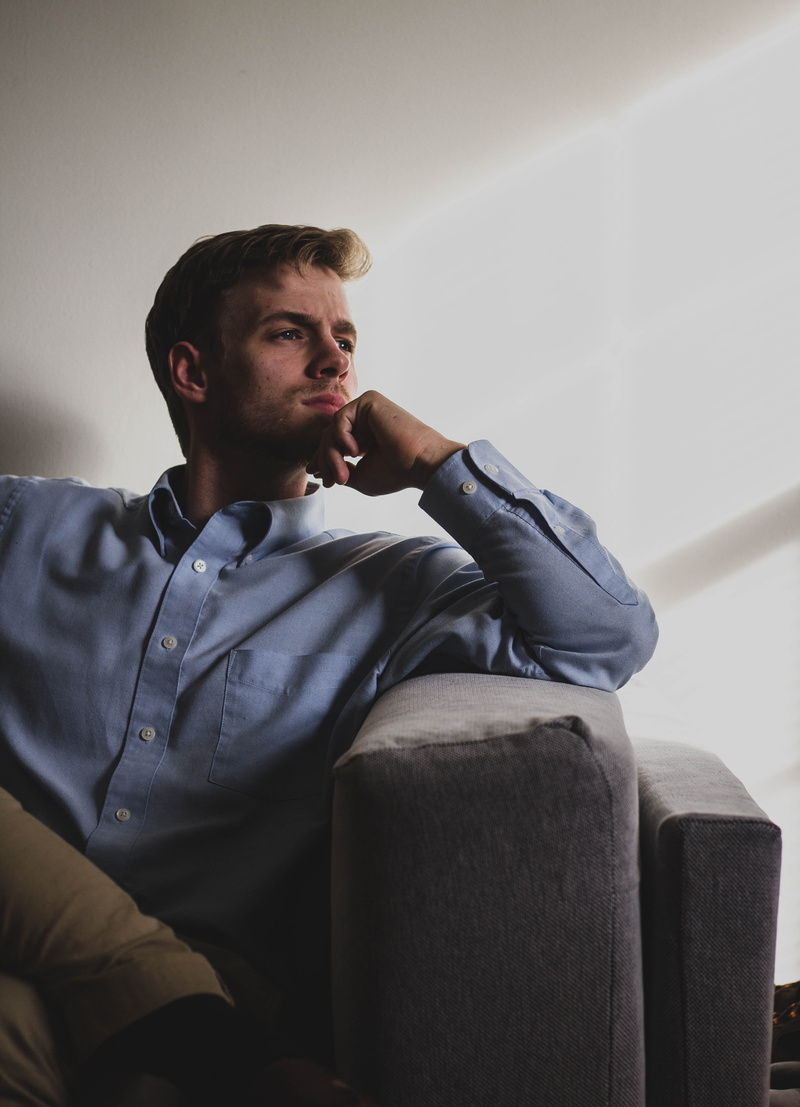 couch, one person, front view, sad, lifestyles, greensboro, man, young men, sitting, sofa, looking, united states, contemplation, indoors, casual clothing