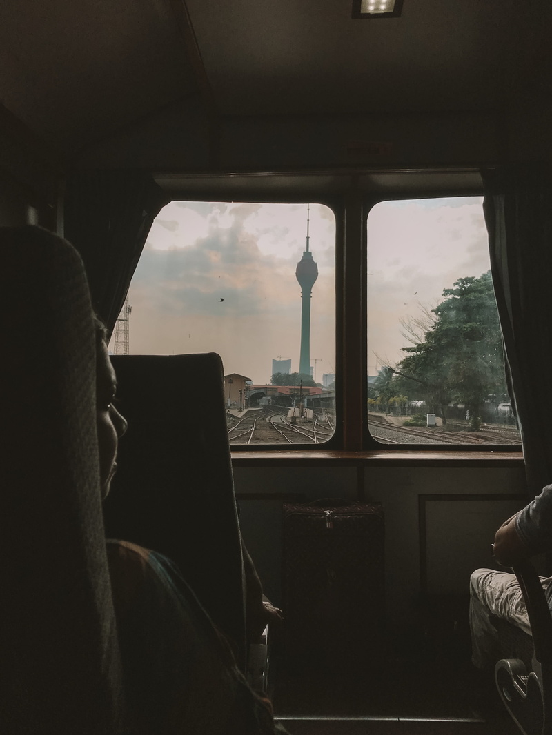 inside, real people, land vehicle, tower, one person, outdoors, seat, train, person, indoors, chair, building, screen, cushion, home decor, window, human